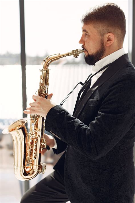 Adult man playing saxophone on event with inspiration · Free Stock Photo