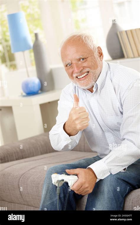 Älterer Mann, der mit dem Computerspiel den Daumen nach oben gibt Stockfotografie - Alamy