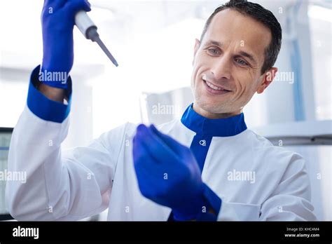 Joyfull laboratorian waiting for chemical reaction Stock Photo - Alamy