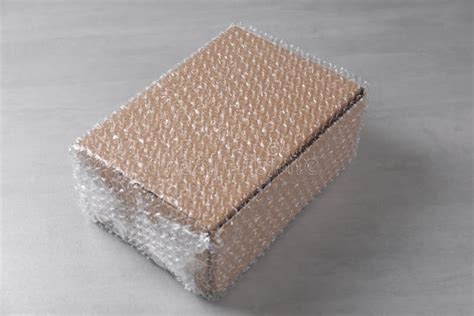 Cardboard Box Covered with Bubble Wrap on Light Grey Table Stock Image ...