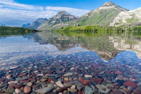 Colorful Rocks on Driftwood Beach, with Relfection of the Prince of Wales Hotel in Waterton ...