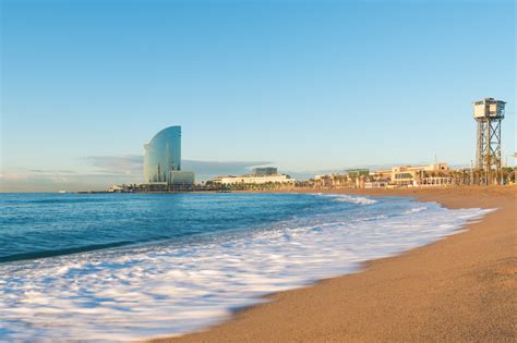 Barceloneta Beach in Barcelona with colorful sky at sunrise. Sea - 9 Story Media Group