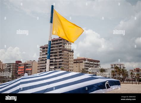 Yellow flag on the beach in Gandia, Spain Stock Photo - Alamy