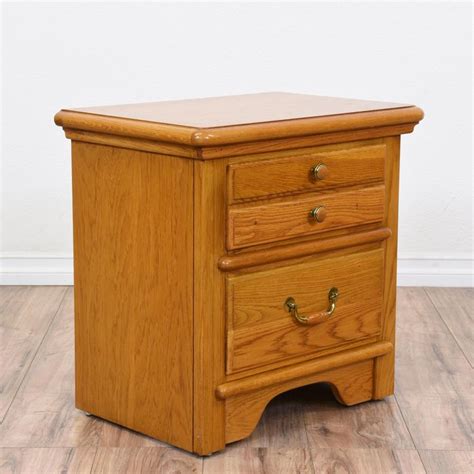 This "Lexington" nightstand is featured in a solid wood with a glossy honey oak finish. This end ...