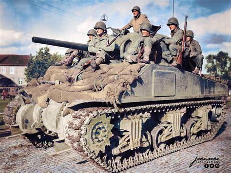 US Infantry riding on an M4 Sherman tank of the 33rd Armored Regiment ...