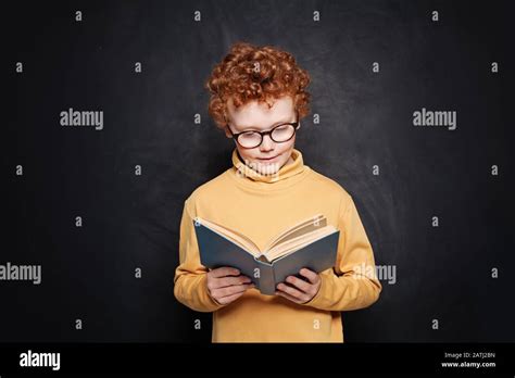 Portrait of little boy in glasses reading a book against blackboard Stock Photo - Alamy