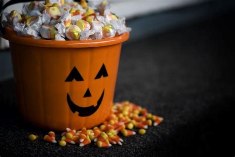 an orange halloween bucket filled with candy and sprinkles that says 10 ...
