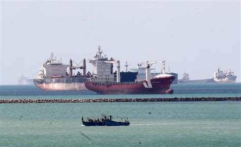 Diggers and dredgers struggle to free ship blocking Suez Canal | Reuters