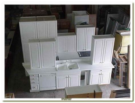 several white cabinets and drawers in a room with boxes stacked on the ...