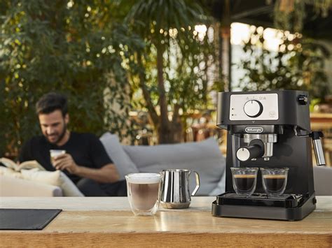 a man sitting on a couch next to a coffee maker