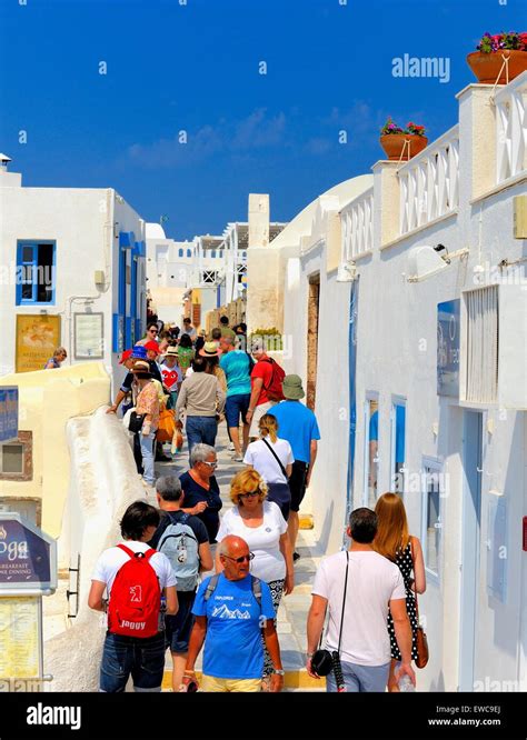 Tourists walking through the busy streets of Oia, Santorini,Greece ...