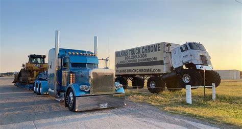 three semi trucks are parked on the side of the road in front of a ...