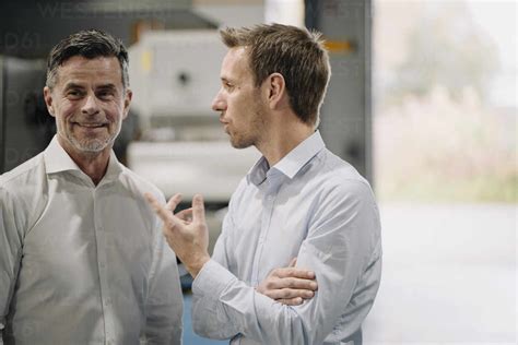 Two men talking in a factory stock photo