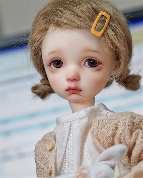 a close up of a doll wearing a sweater