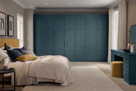 a bed room with a neatly made bed next to a night stand and a dresser