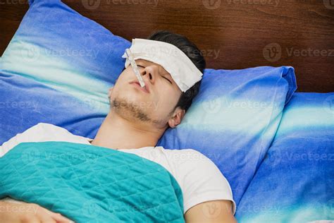 Young man in bed measuring fever with thermometer 1242003 Stock Photo ...