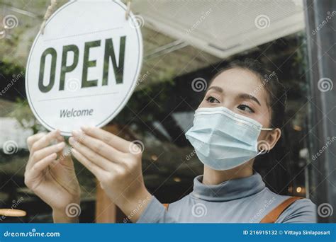 Reopen. Friendly Waitress Wearing Protection Face Mask Turning Open Sign Board on Glass Door in ...