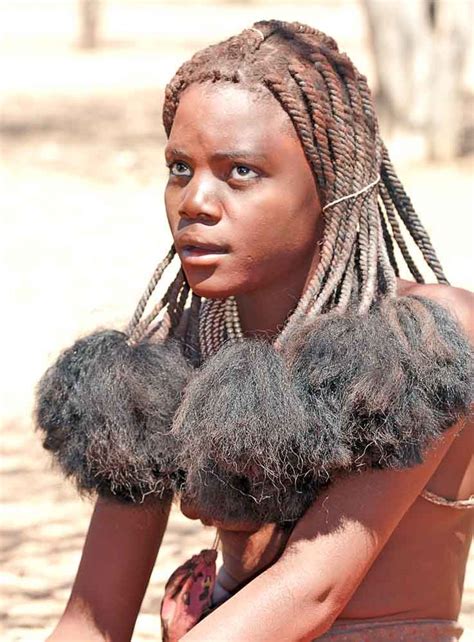 Young Himba woman with traditional hair style. "Each member belongs to ...