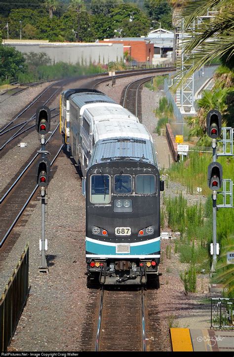 two trains on tracks next to each other with trees and bushes in the ...