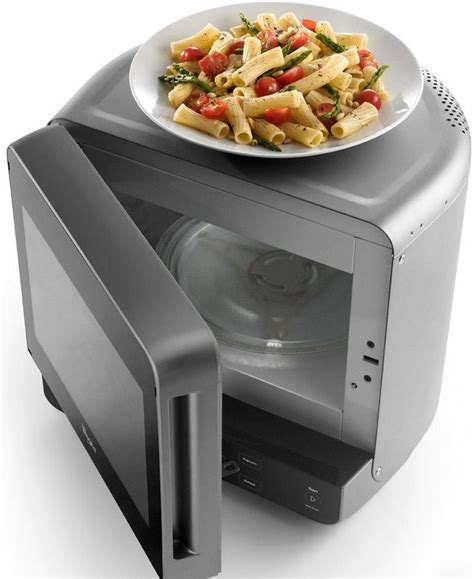 a plate of food sitting on top of an open microwave oven with it's door open