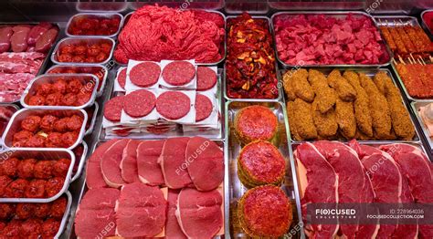 Variety of marinated meat at display counter in butchers shop — selling ...