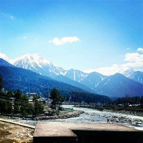 the mountains are covered with snow in the distance, and there is a river running through it