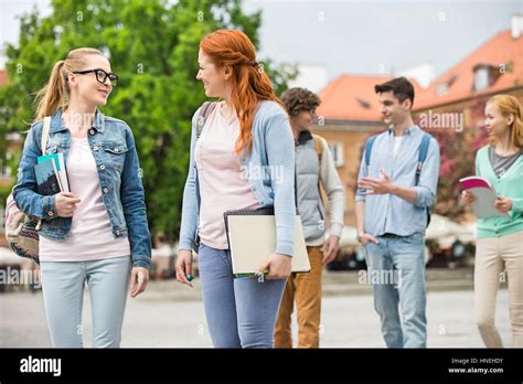 Young college friends walking on street Stock Photo - Alamy