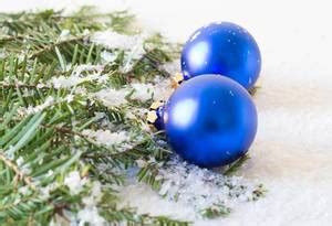 A Christmas lanternis shining on a blue background with branches of a ...