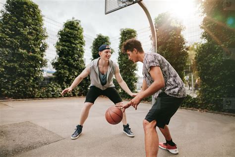 Teenagers playing basketball on outdoor court stock photo (124209) - YouWorkForThem