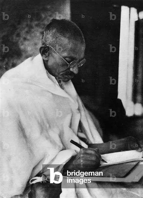 Mahatma Gandhi (1869-1948) writing (b/w photo)