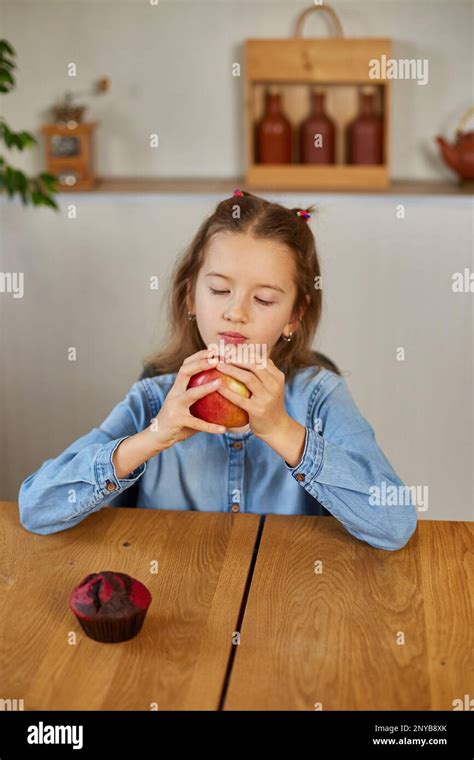 Cute little girl eat red apple at home at kitchen interior, yummy, happy child, Healthy ...