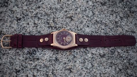 gold watch with a leather strap on Behance