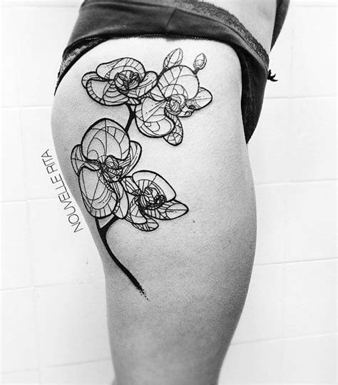 a black and white photo of a woman's thigh with flowers tattooed on it