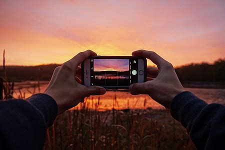 Royalty-Free photo: Man capturing nature photo with his mobile iPhone smartphone | PickPik