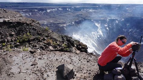 Hawaiian Volcano Observatory scientist installing a new battery in a Halema‘uma‘u crater webcam ...