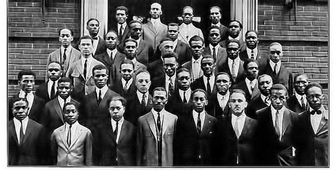 a group of men standing next to each other in front of a building