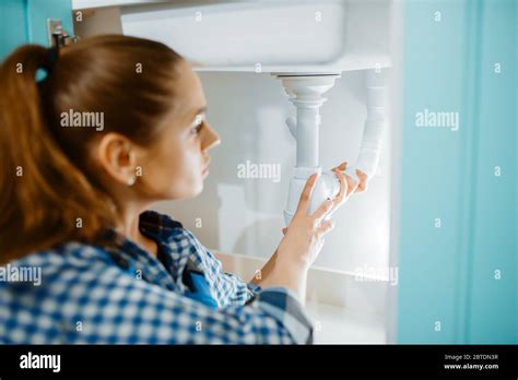 Female plumber in uniform installing drain pipe Stock Photo - Alamy