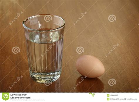 A Full Glass of Water and One Egg on Scratched Brown Wooden Table Stock Image - Image of fresh ...