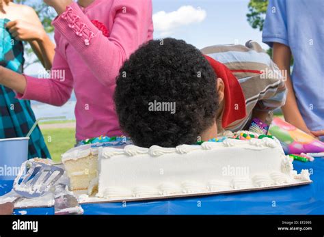 Child putting his face in a birthday cake Stock Photo - Alamy