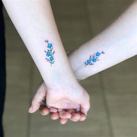 two people holding hands with small blue flowers on their wrist ...