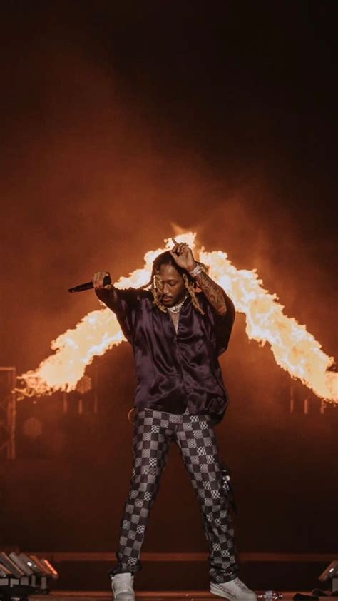 a man standing on top of a stage holding a microphone in front of a fire