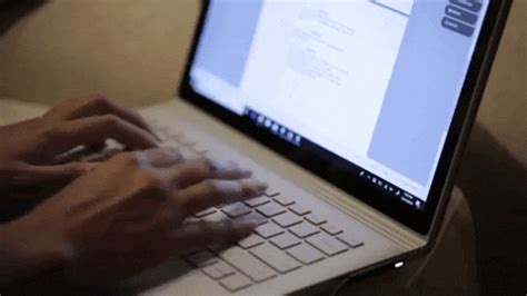 a person typing on a laptop with their hands