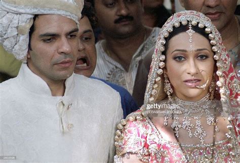 Indian film actress Karishma Kapoor (R) and her new husband Sanjay Kapoor (L) stand for a photo ...