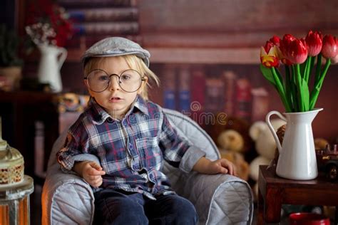 Sweet Toddler Boy, Wearing Glasses, Reading a Book and Drinking Tea with Cookies Stock Image ...