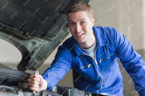 Premium Photo | Male mechanic working on automobile engine