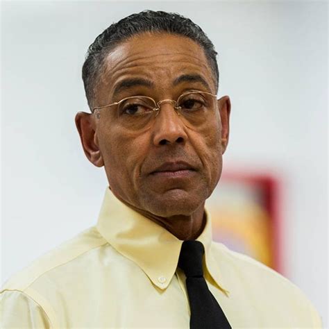 a man wearing glasses and a yellow shirt with a black tie is looking at the camera