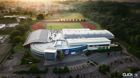 an aerial view of a sports stadium with the sun setting in the background