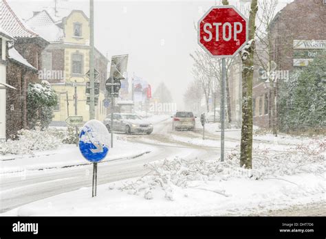 Stop sign on a snowy road crossing Stock Photo - Alamy