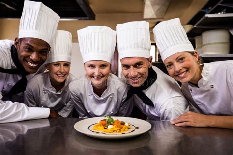 Group of Chefs Looking at Prepared Pasta in Kitchen Stock Photo - Image of black, mature: 135827338