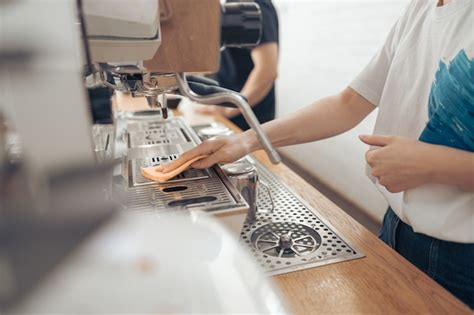 Premium Photo | Female barista cleaning coffee machine in cafeteria